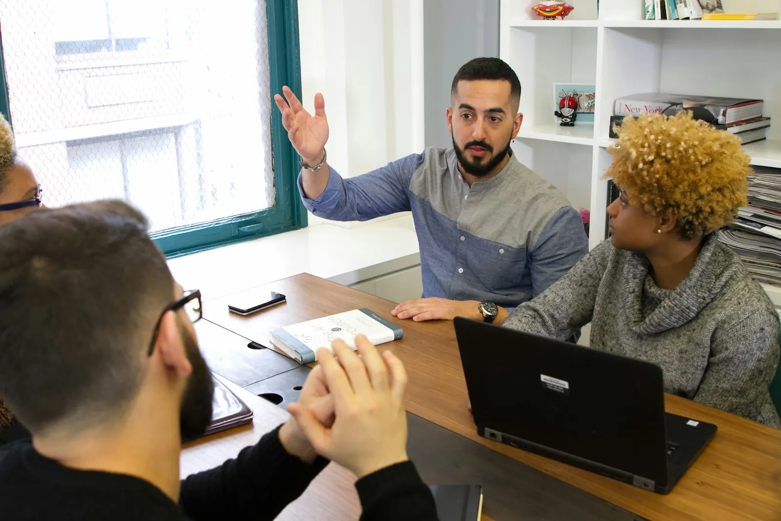 Team member raising a hand to ask a question in a meeting