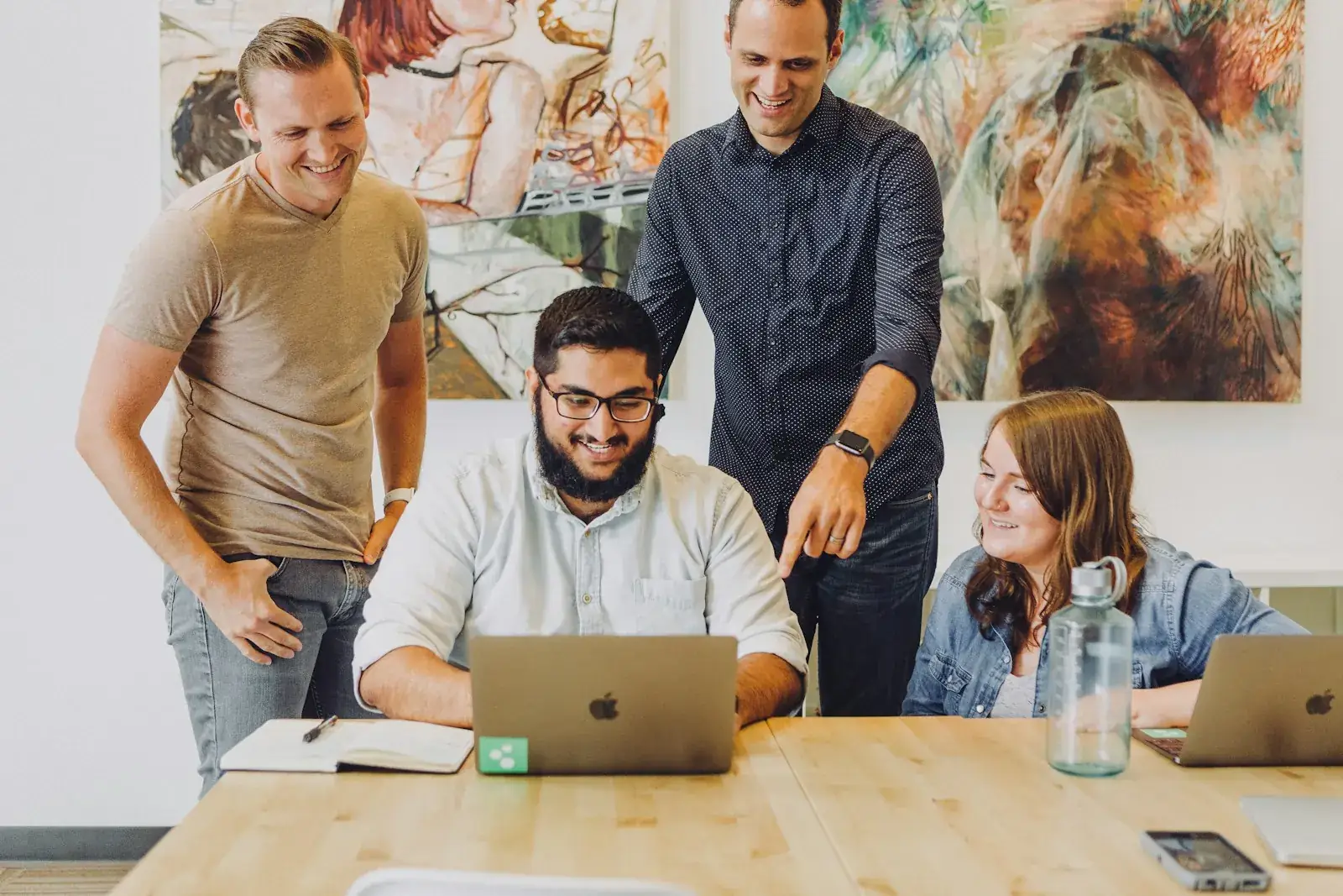 Coworkers working together around a laptop